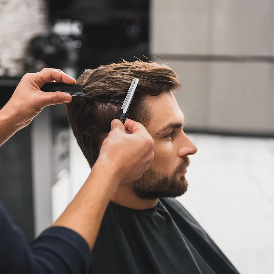 Mann beim Friseur bekommt Haarschnitt